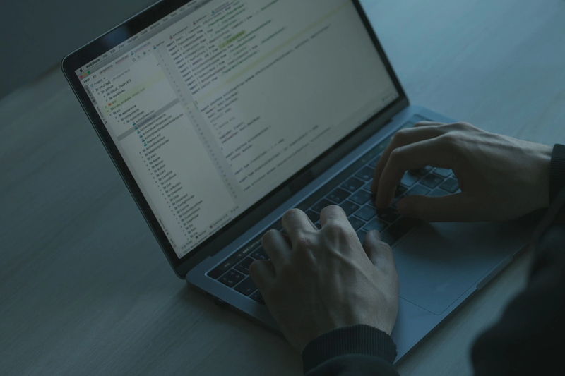 Developer coding an email API on a laptop